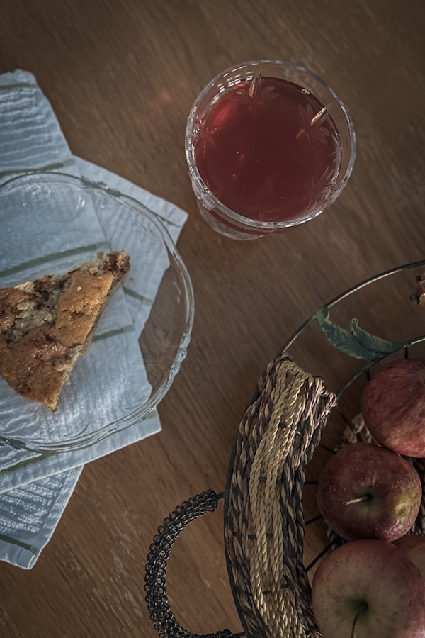 A basket of apples next to a glass of tea