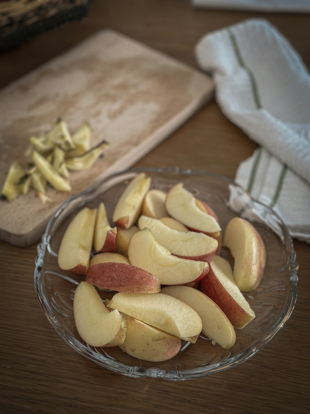 a glass bowl filled with sliced apples on top of a table