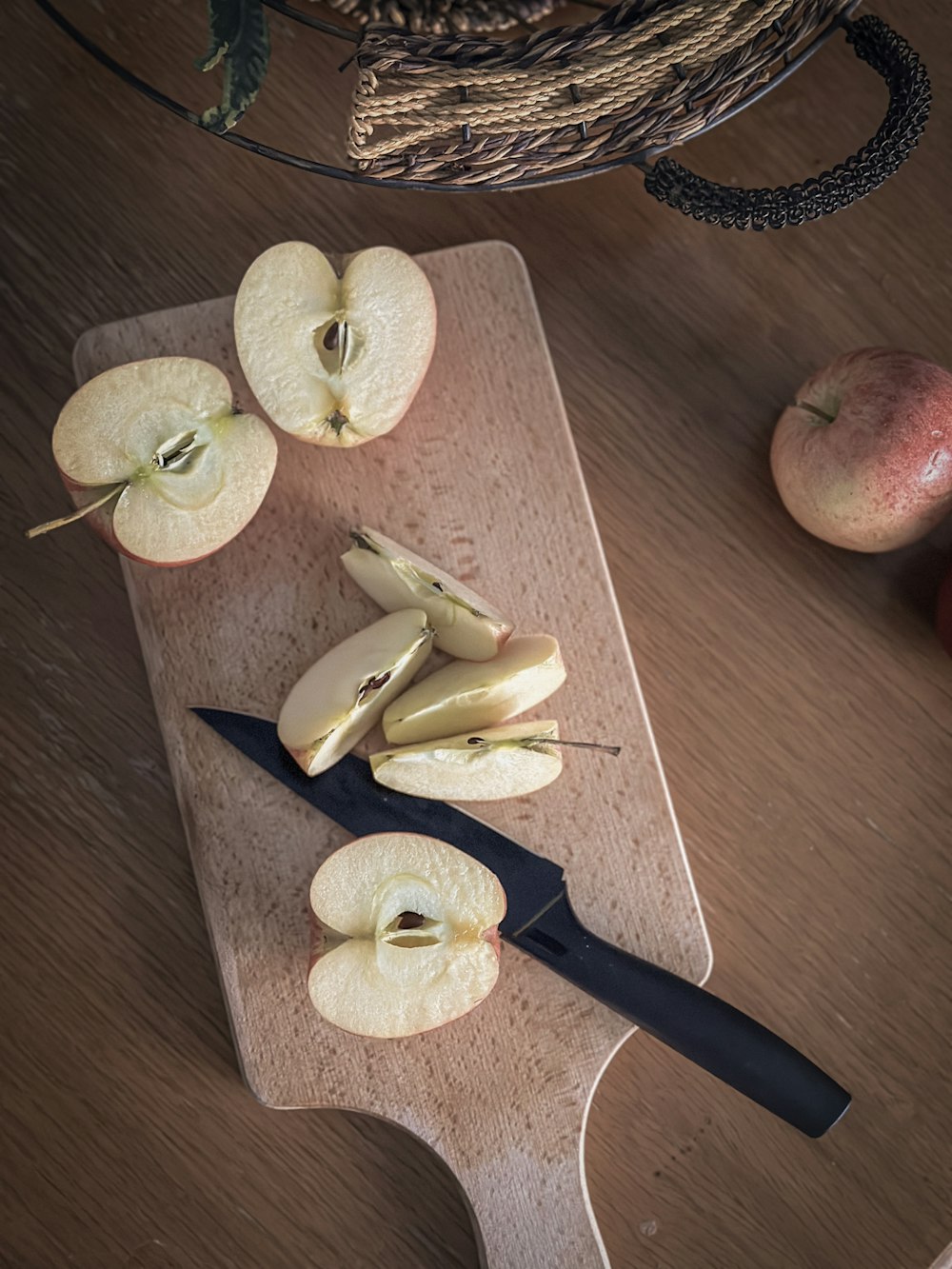 une planche à découper garnie de pommes tranchées et d’un couteau