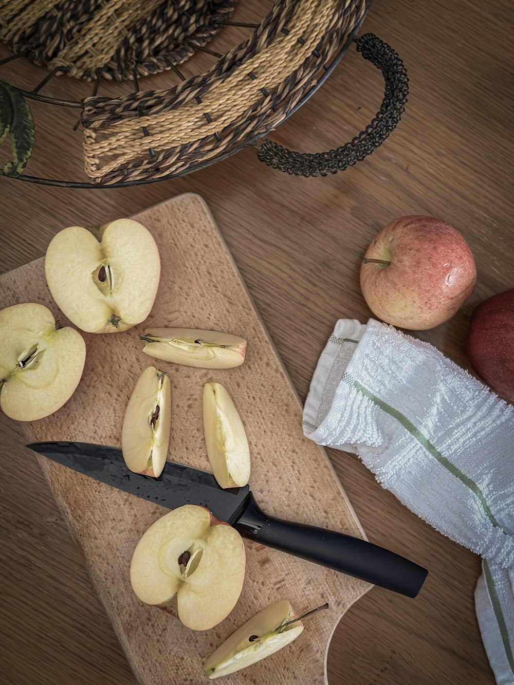 a cutting board topped with sliced apples and a knife