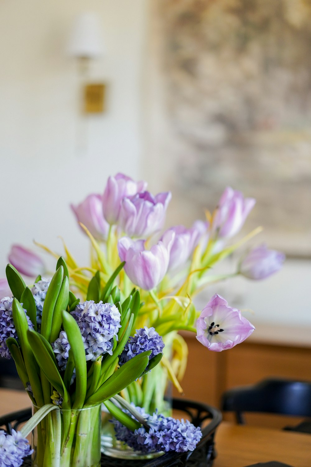 a vase filled with purple flowers on top of a wooden table