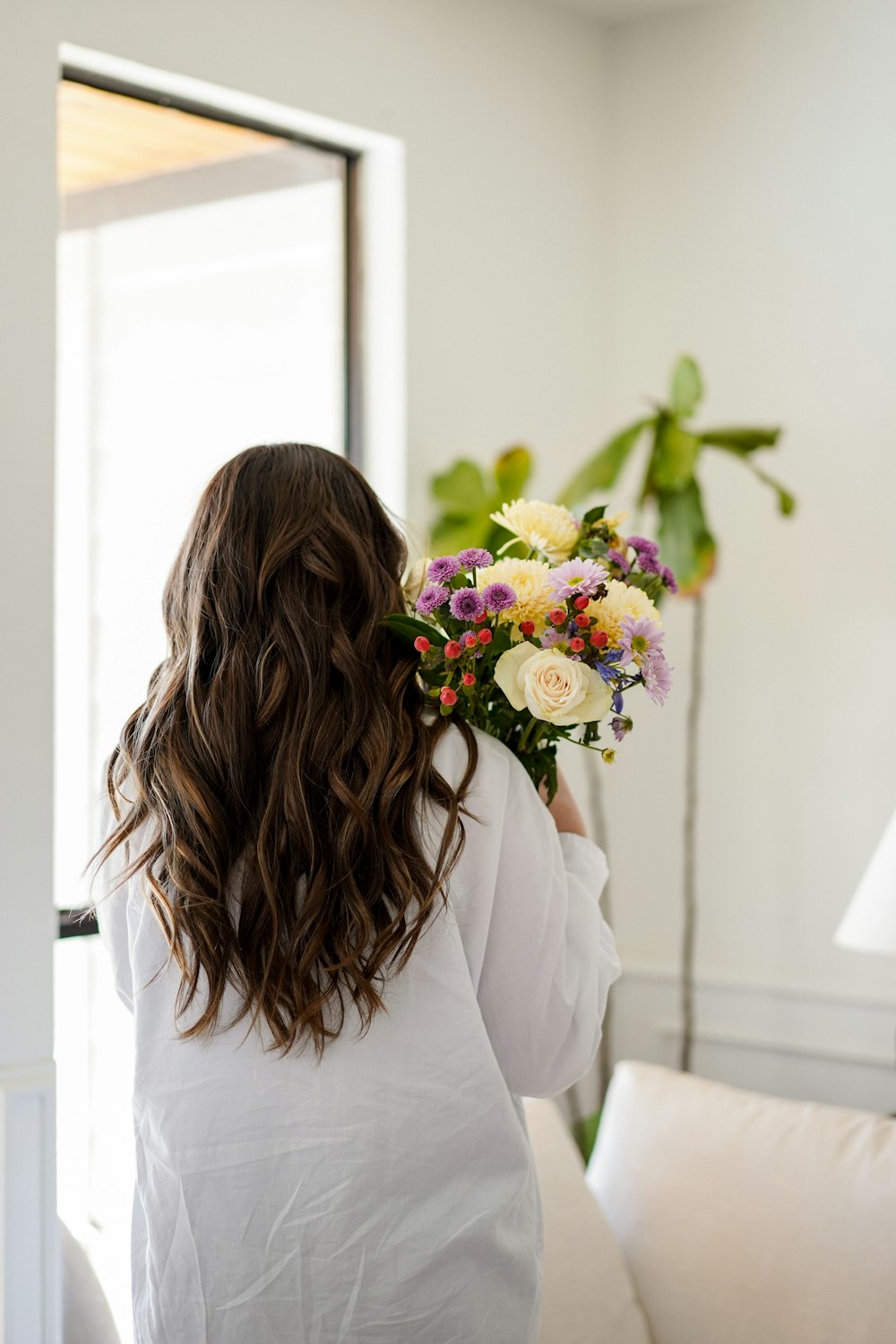 a woman holding a bouquet of flowers in her hand