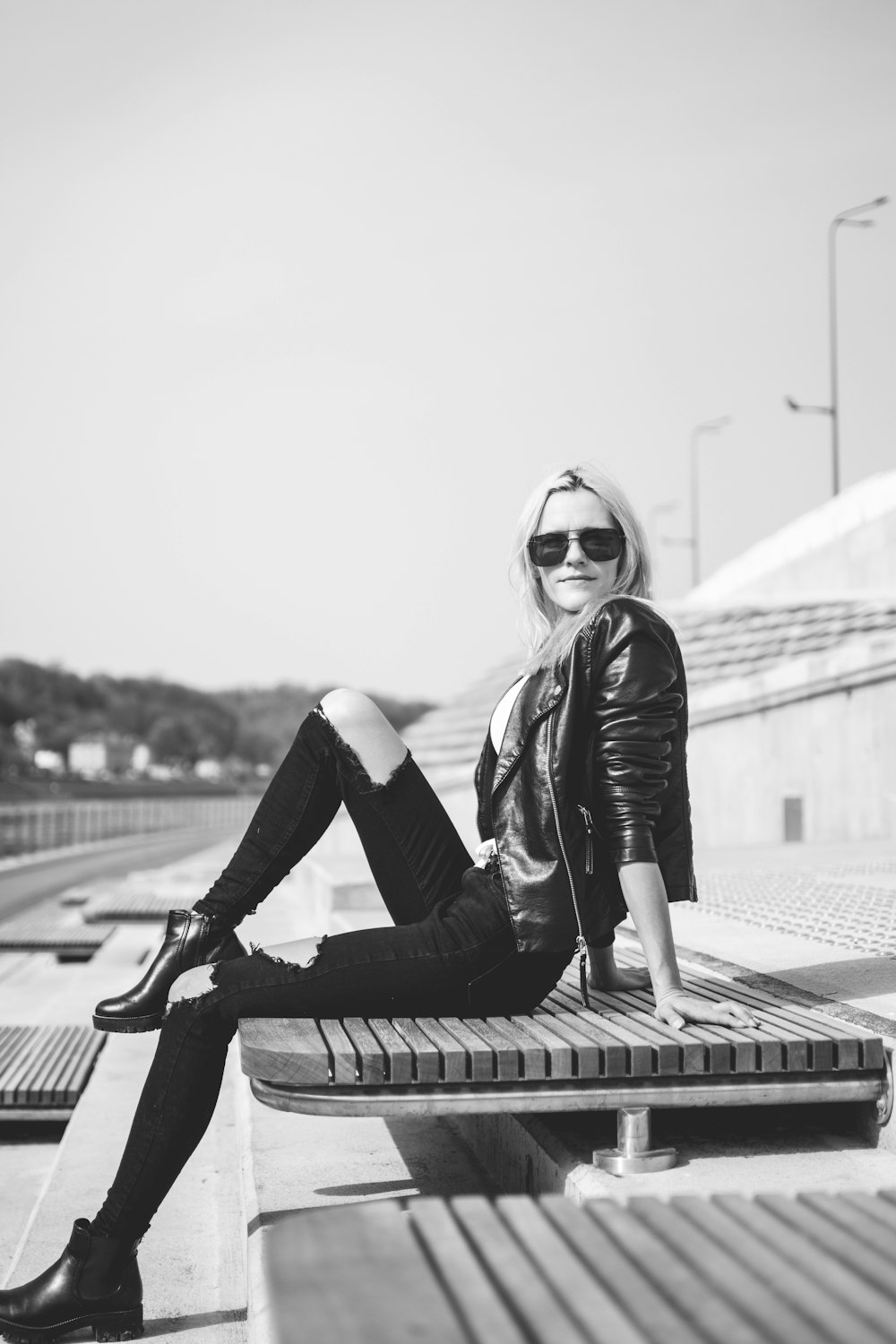 a woman sitting on top of a wooden bench