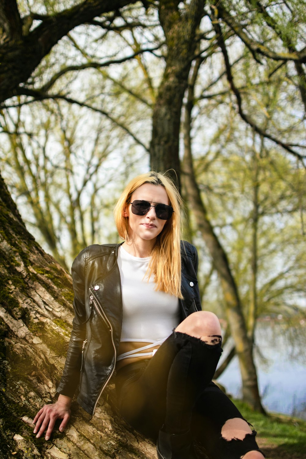 a woman sitting on a rock in the woods