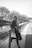 a woman leaning on a rail next to a body of water