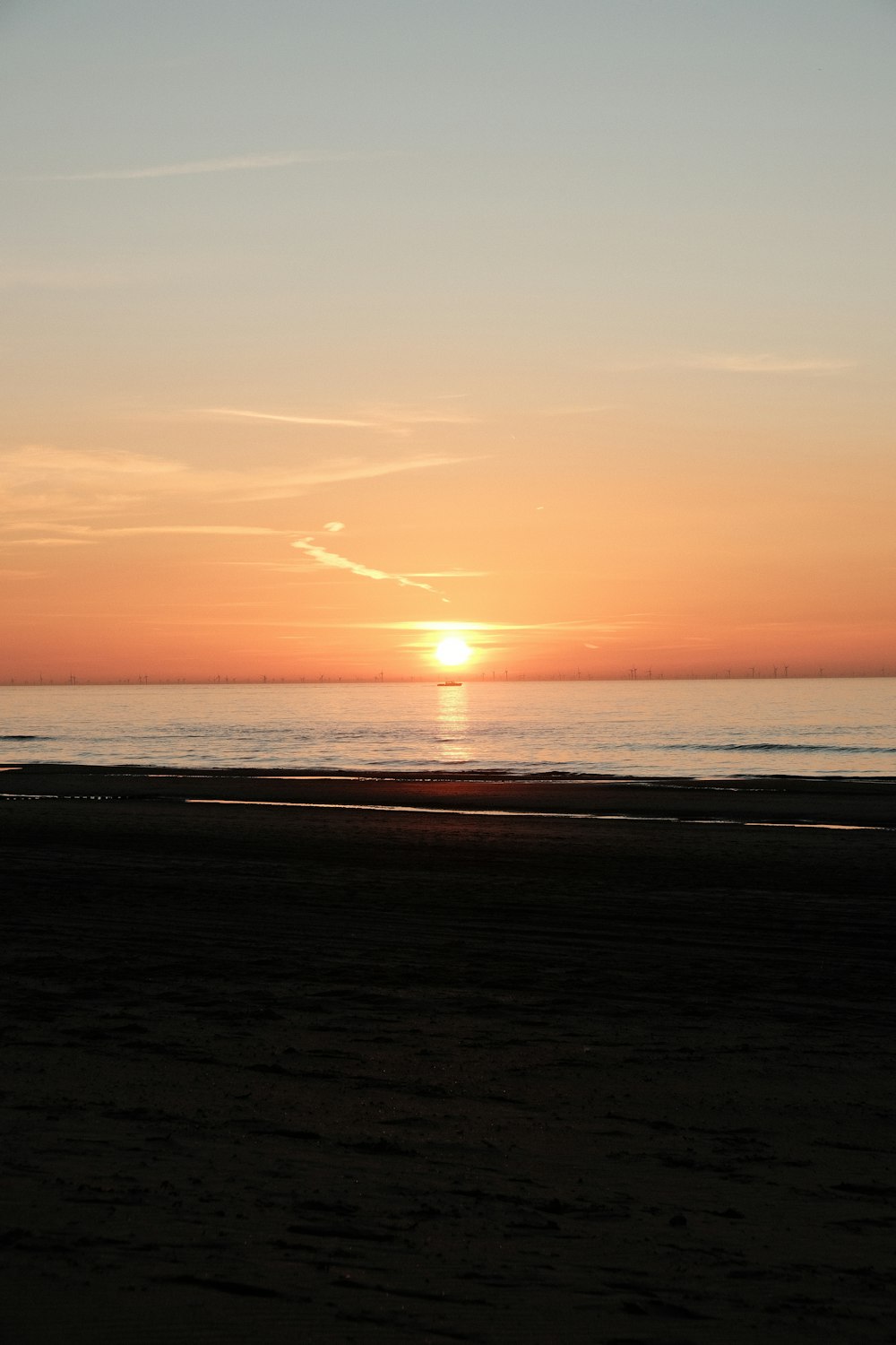 el sol se está poniendo sobre el océano en la playa