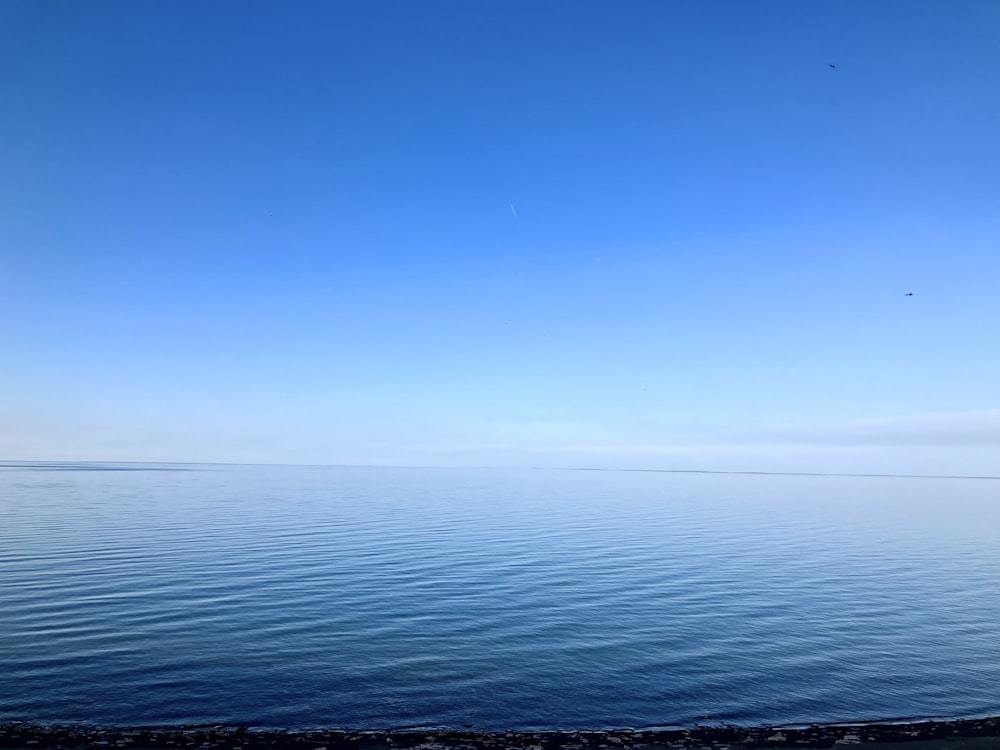 un grande specchio d'acqua seduto sotto un cielo blu