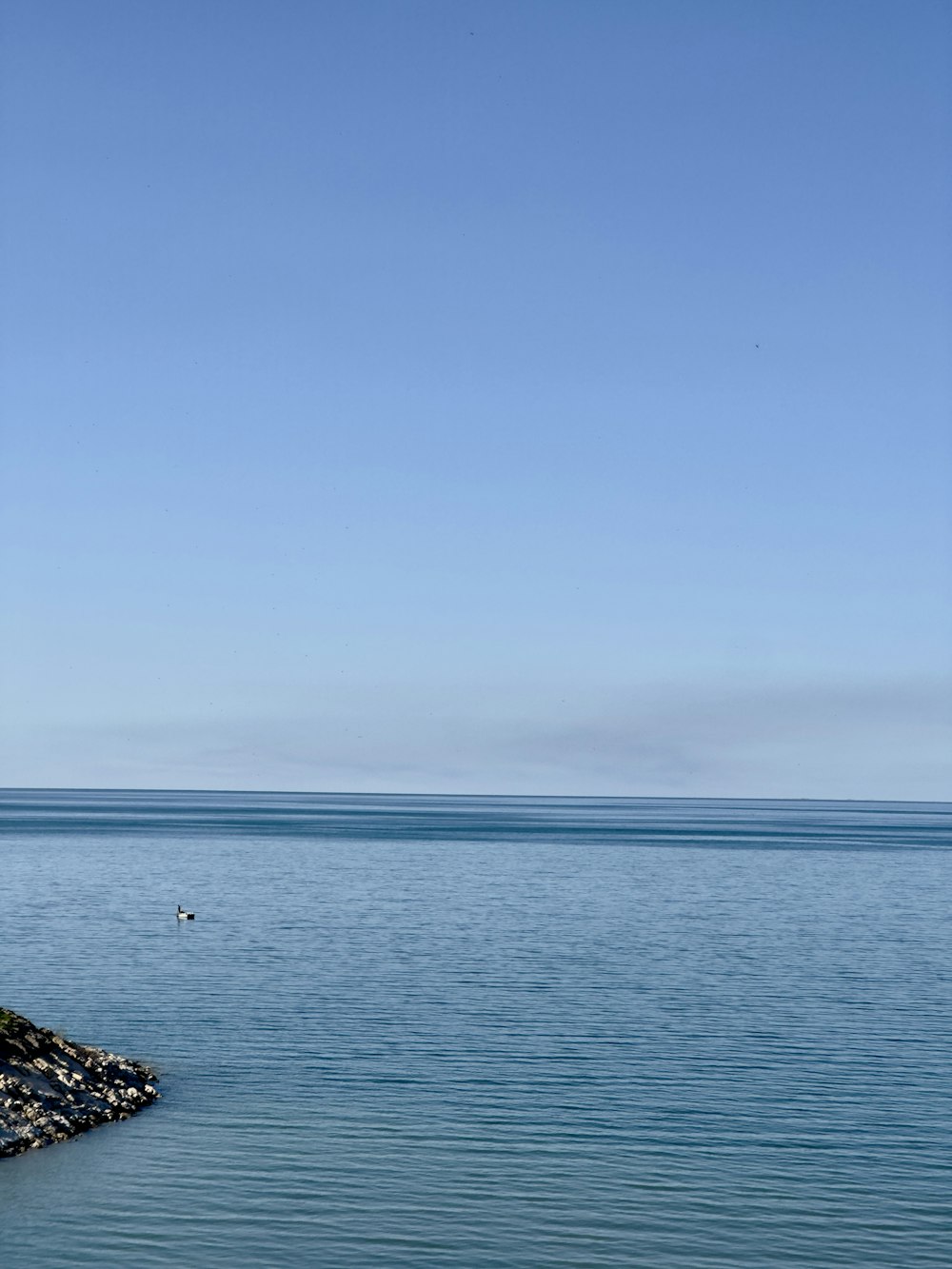 a large body of water sitting under a blue sky