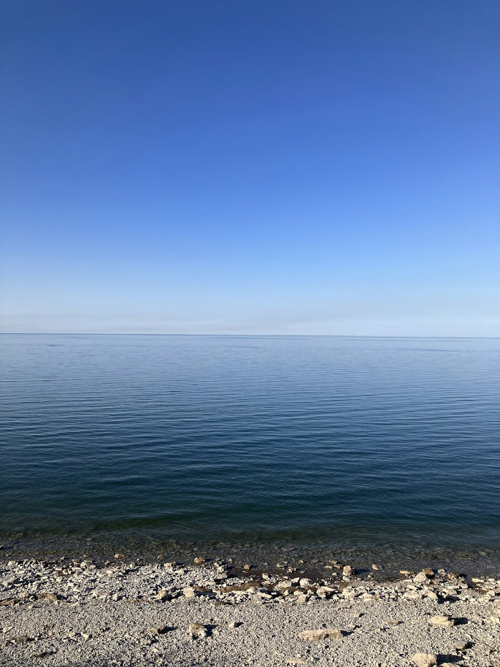 un grande specchio d'acqua seduto accanto a una spiaggia sabbiosa