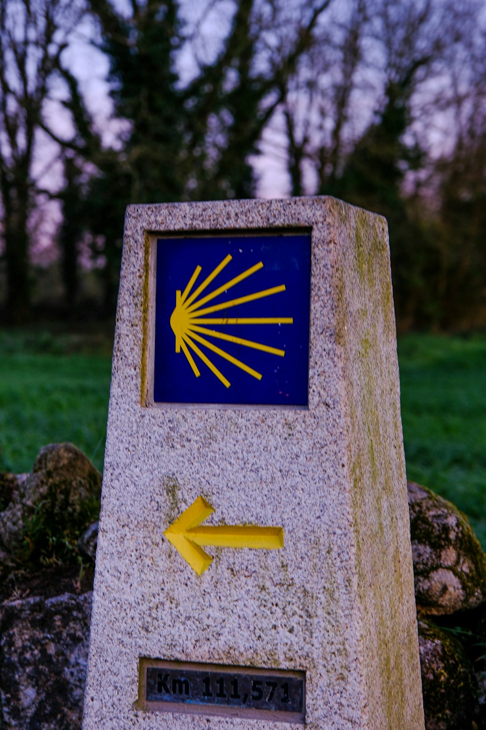 a stone monument with a yellow arrow pointing to the right