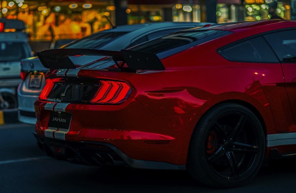 a red mustang mustang parked in a parking lot