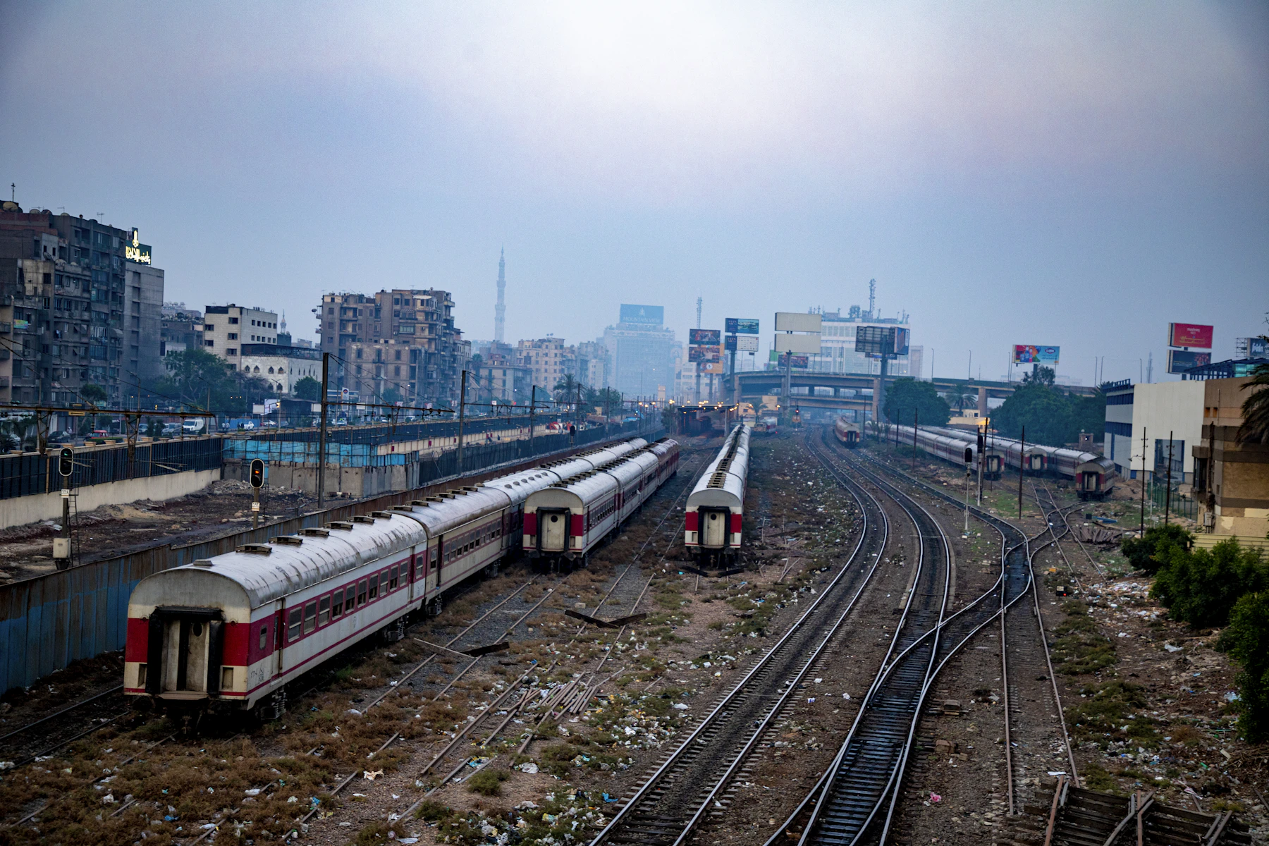Two passenger trains stand on parallel railway tracks in Cairo.