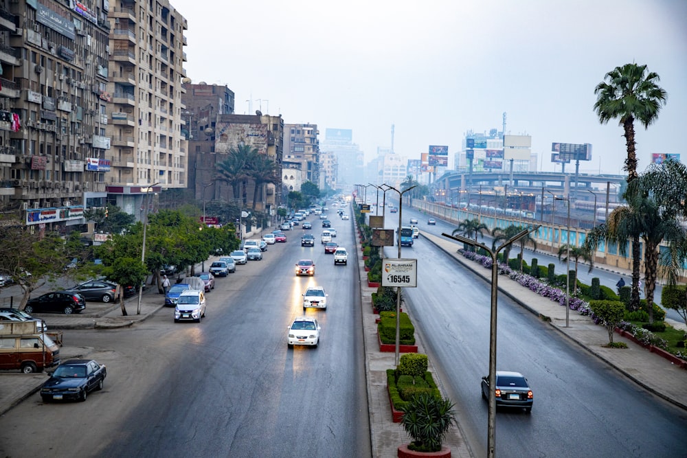 a city street filled with lots of traffic next to tall buildings