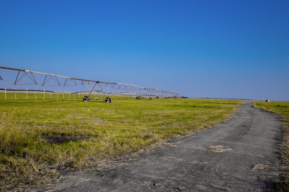 a farm field with a line of sprinklers in the distance