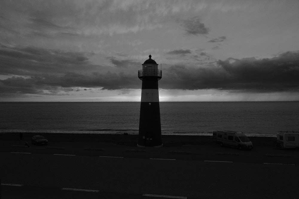 Uma foto em preto e branco de um farol perto do oceano