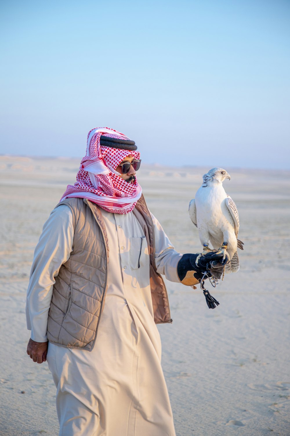 a man in a desert holding a bird