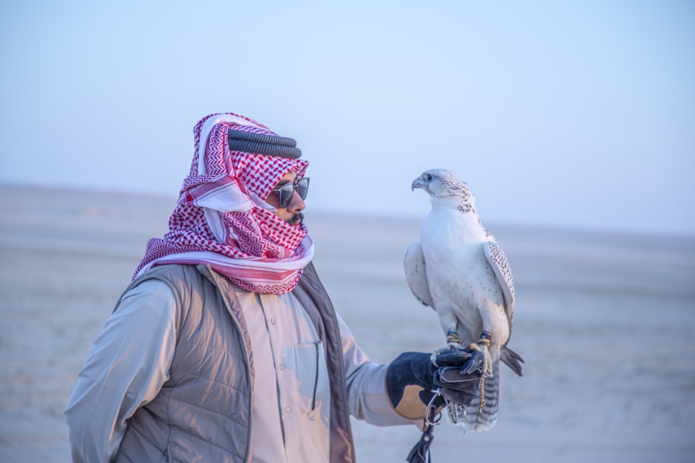 a man holding a white bird on his arm