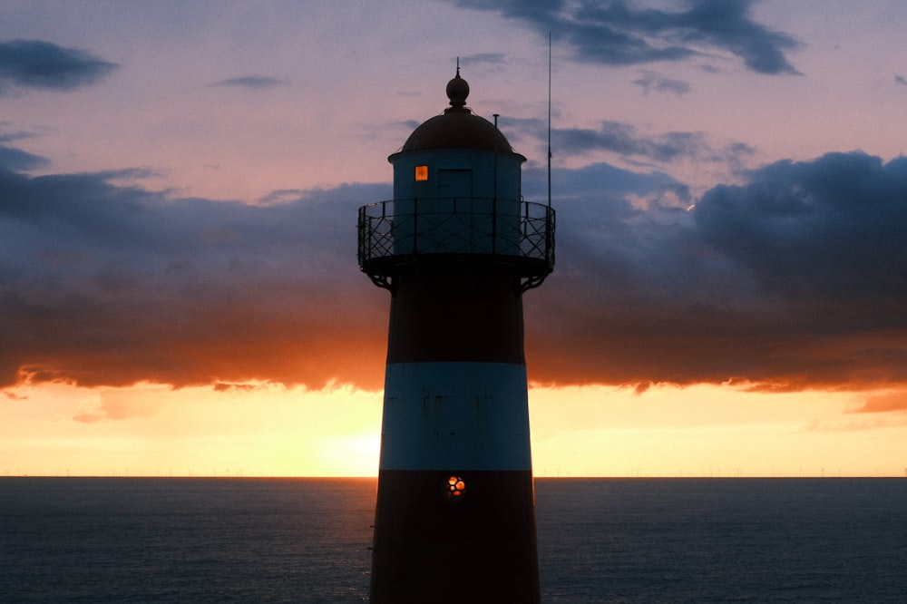 a light house sitting in the middle of a body of water