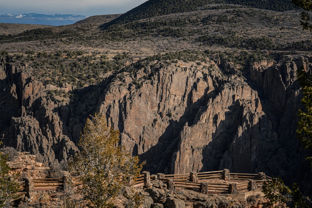 a large mountain with a wooden fence in front of it