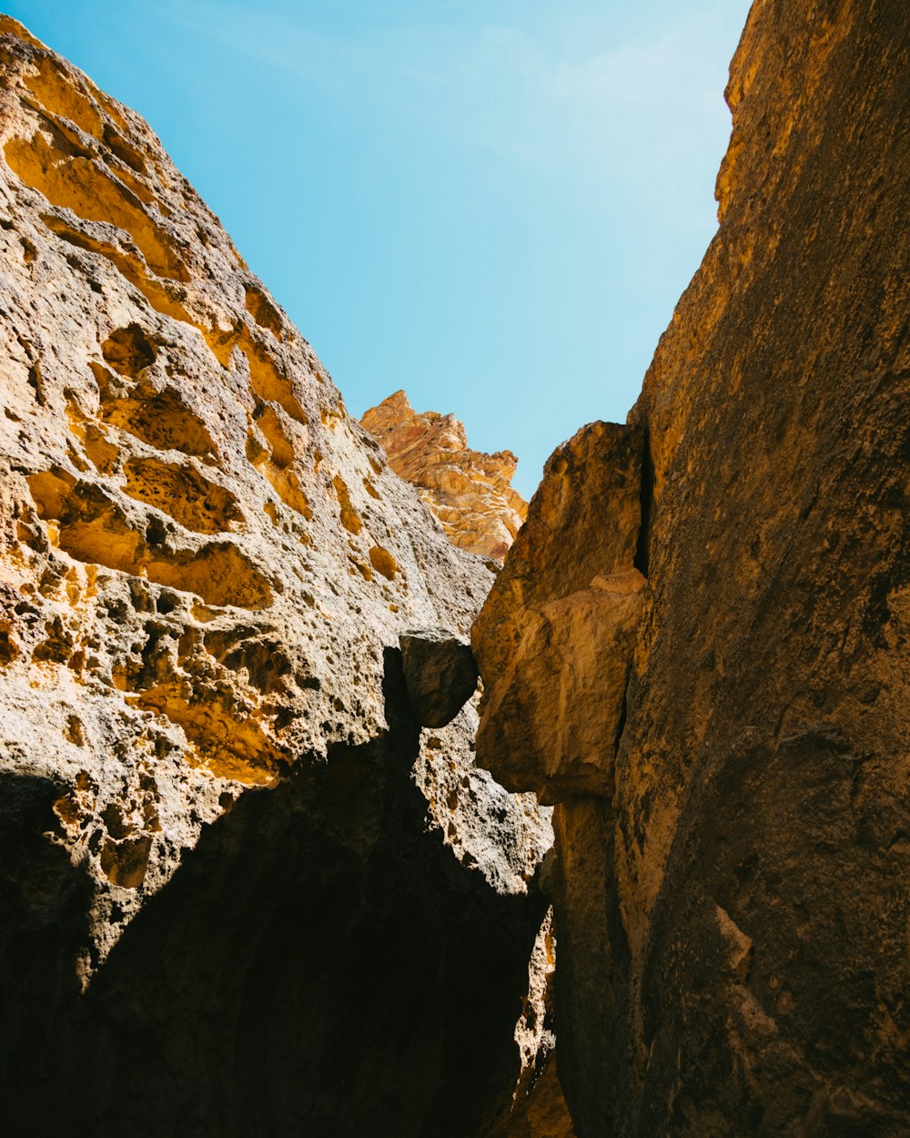 a person climbing up a rock face on a sunny day