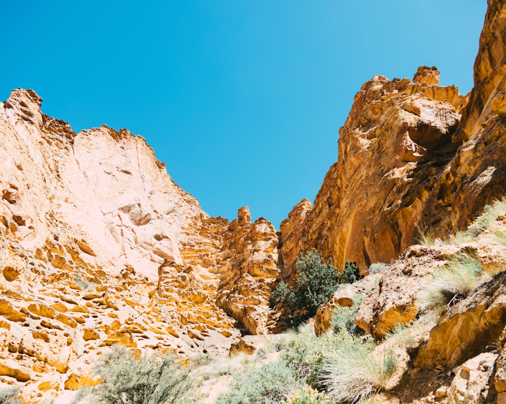 a rocky mountain side with a blue sky in the background