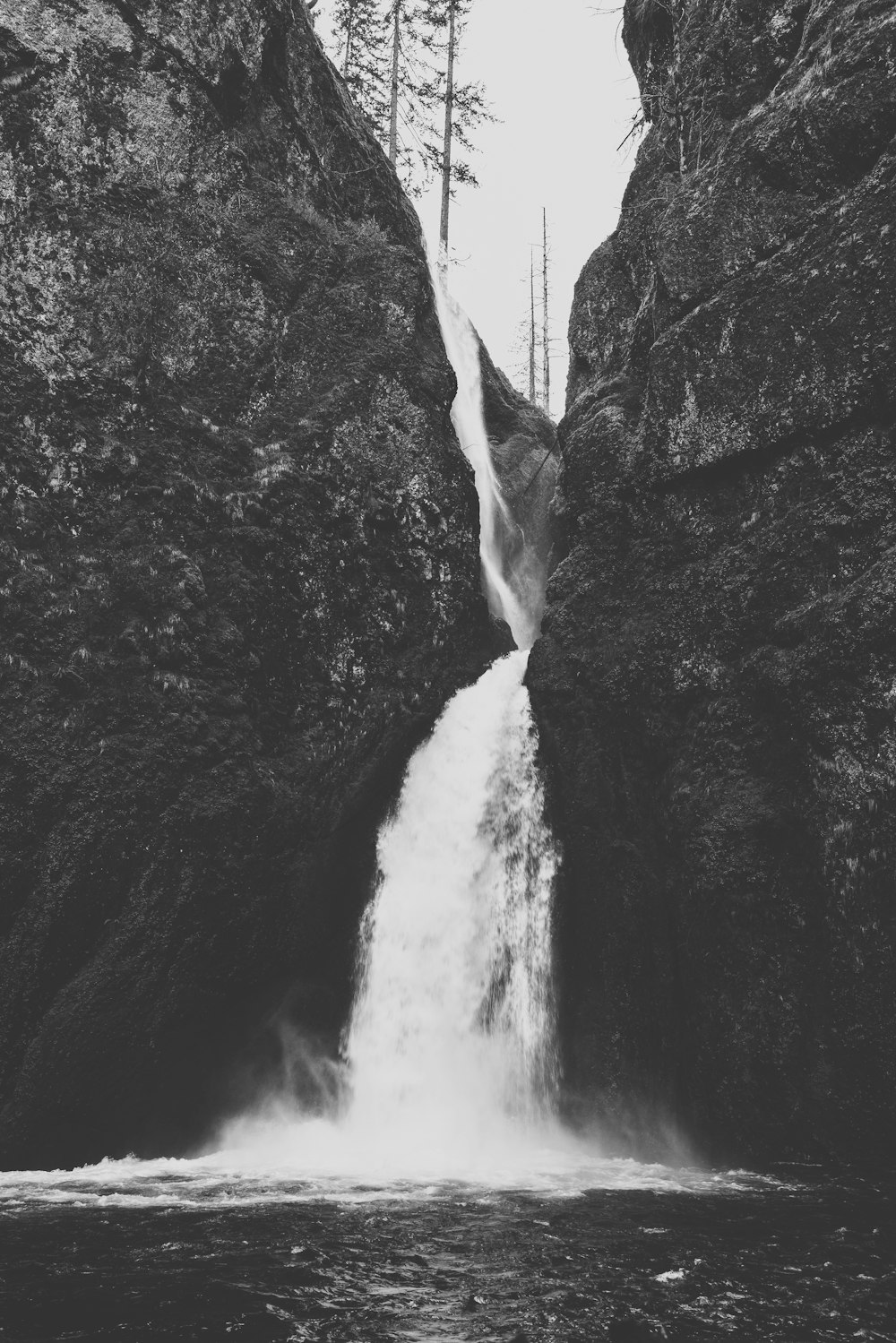 a black and white photo of a waterfall