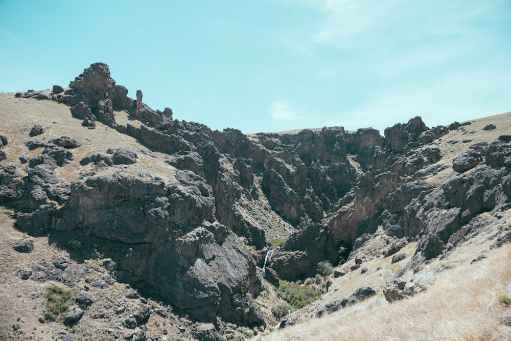 a view of a rocky mountain with a stream running through it