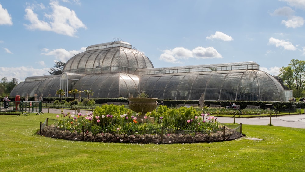 a large glass building with a fountain in the middle of it