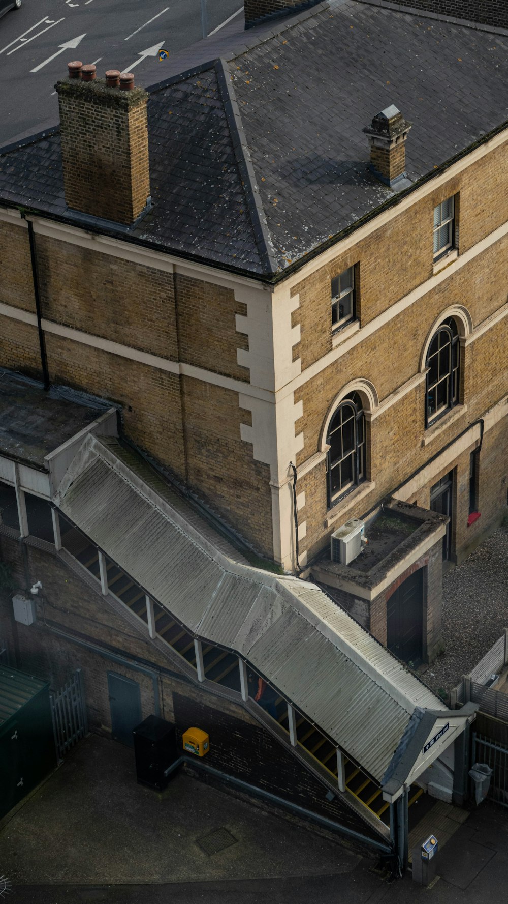 an aerial view of a building with a walkway going up the side of it