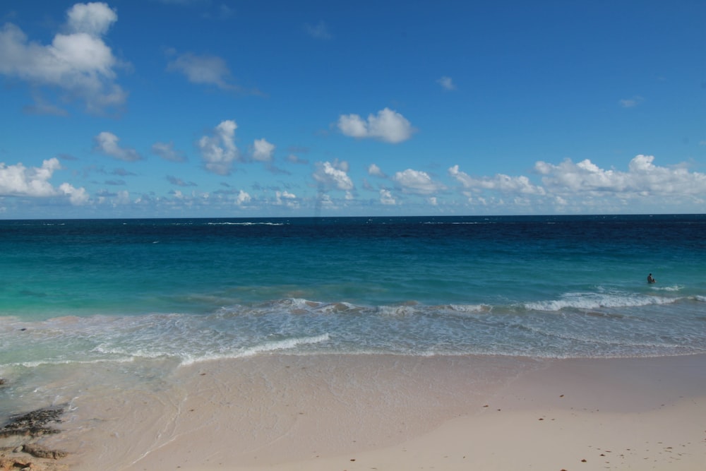 a beach with a person in the water