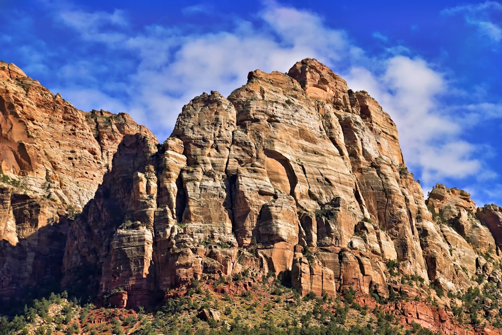 a rocky mountain with a blue sky in the background