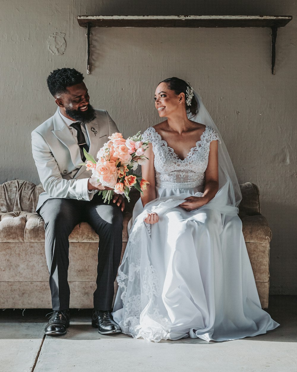 a bride and groom sitting on a couch