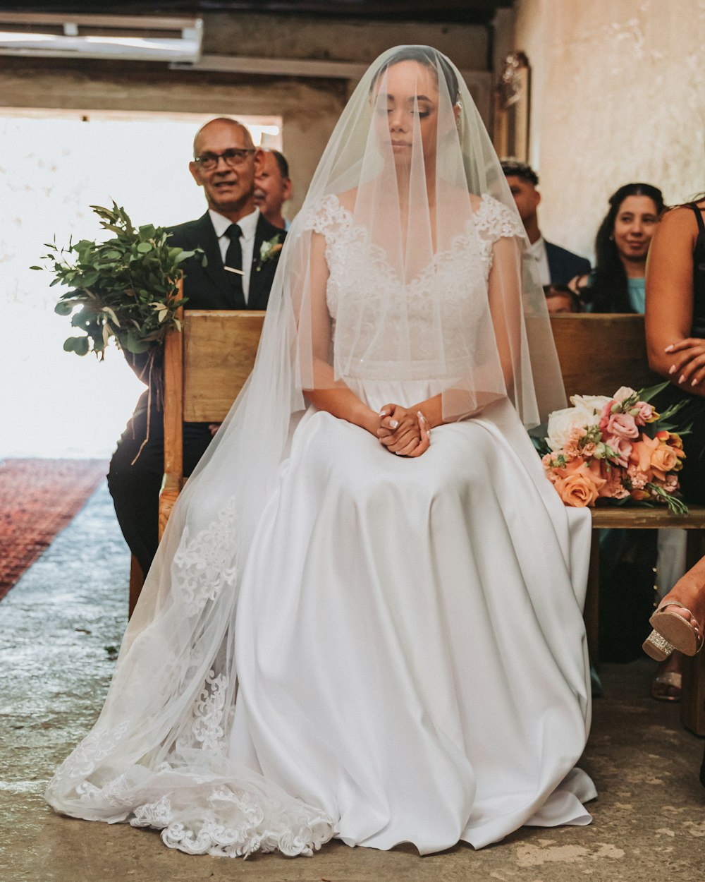 a woman in a wedding dress sitting on a bench