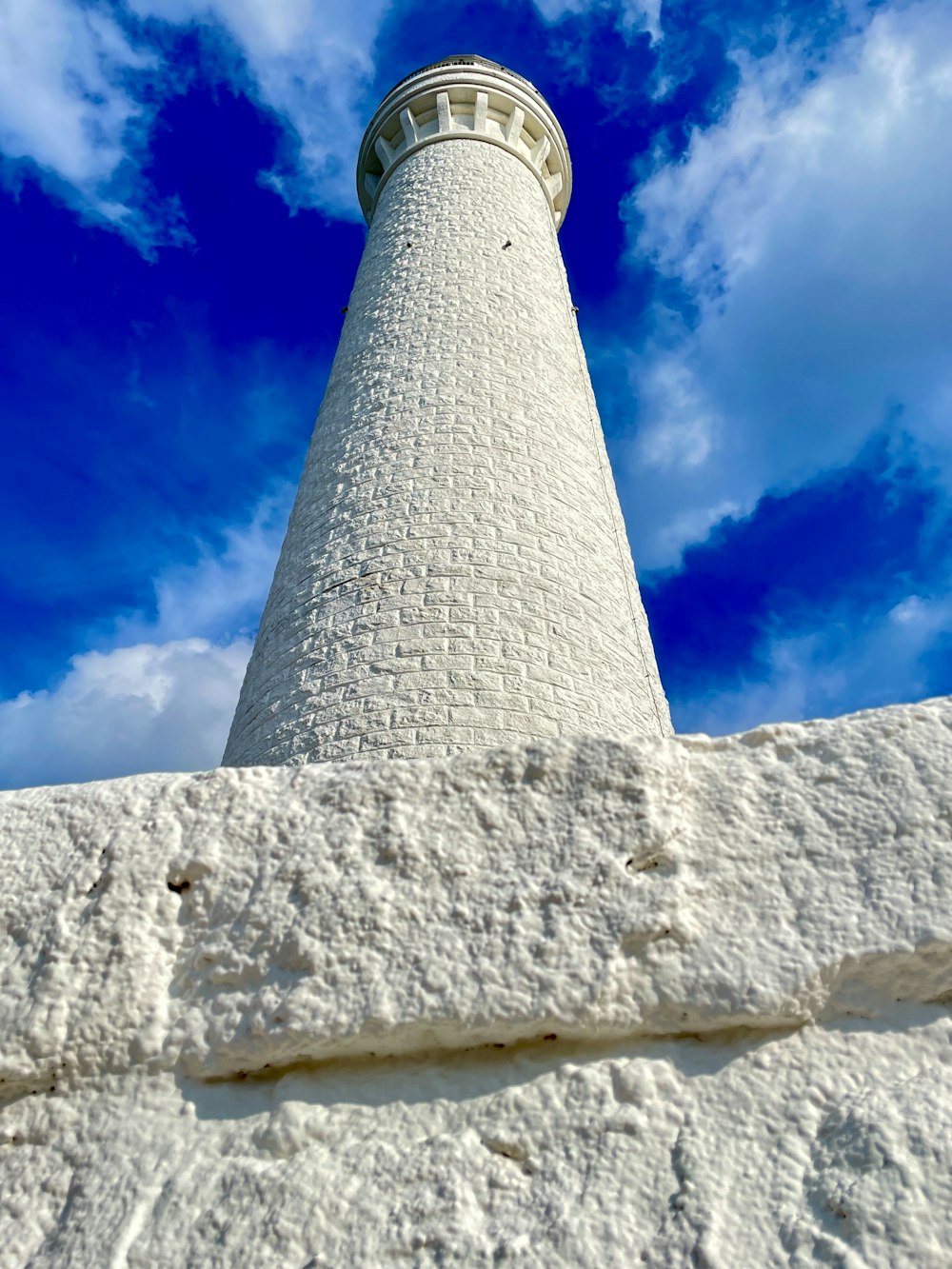 a white lighthouse with a blue sky in the background