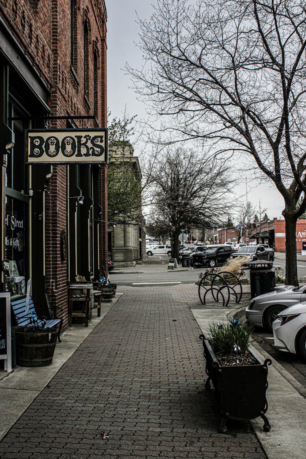 a brick sidewalk with a sign that reads books on it