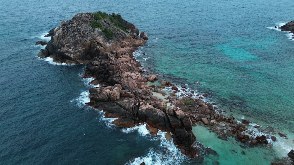 an aerial view of a rocky coastline with clear blue water