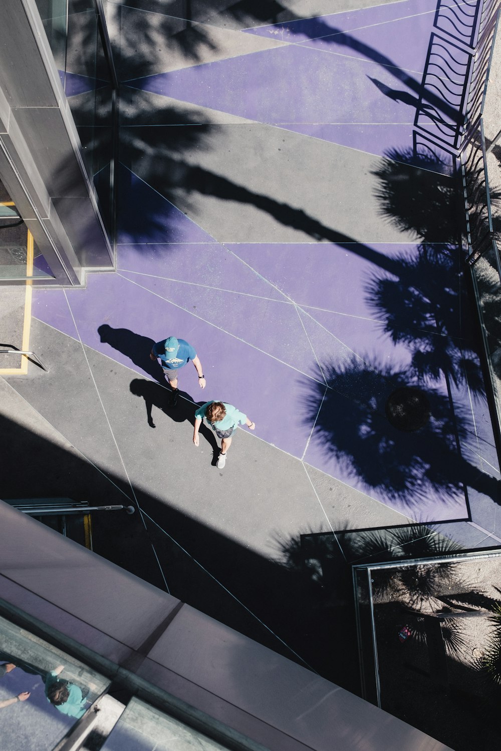 a person walking down a sidewalk next to a tall building