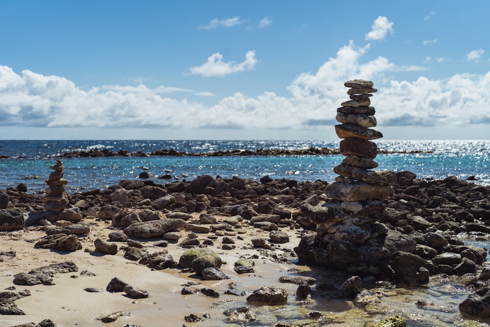 a stack of rocks sitting on top of a sandy beach