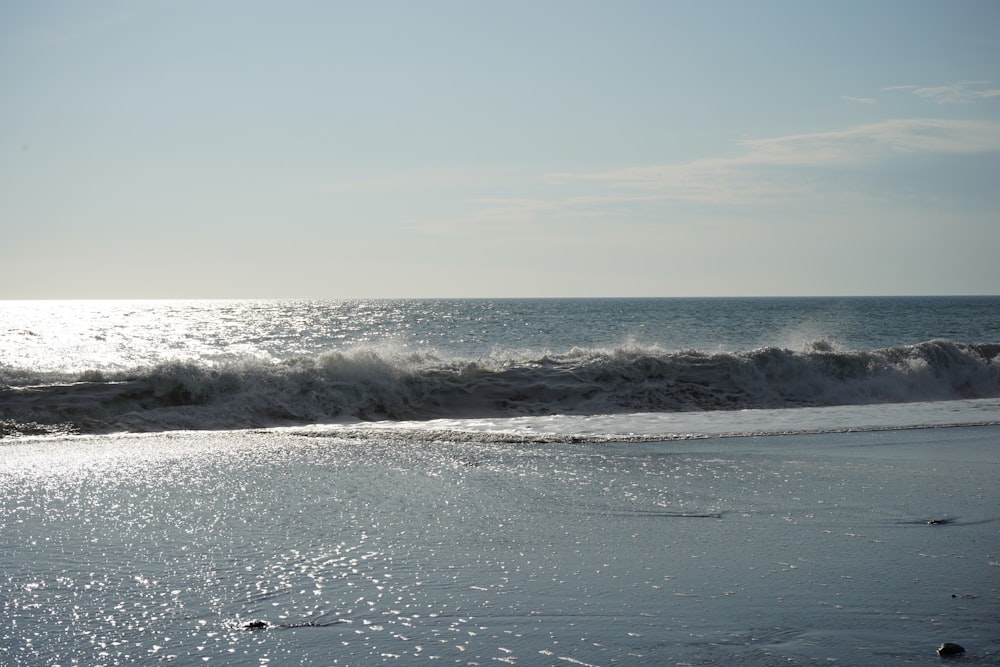 a person walking on the beach with a surfboard