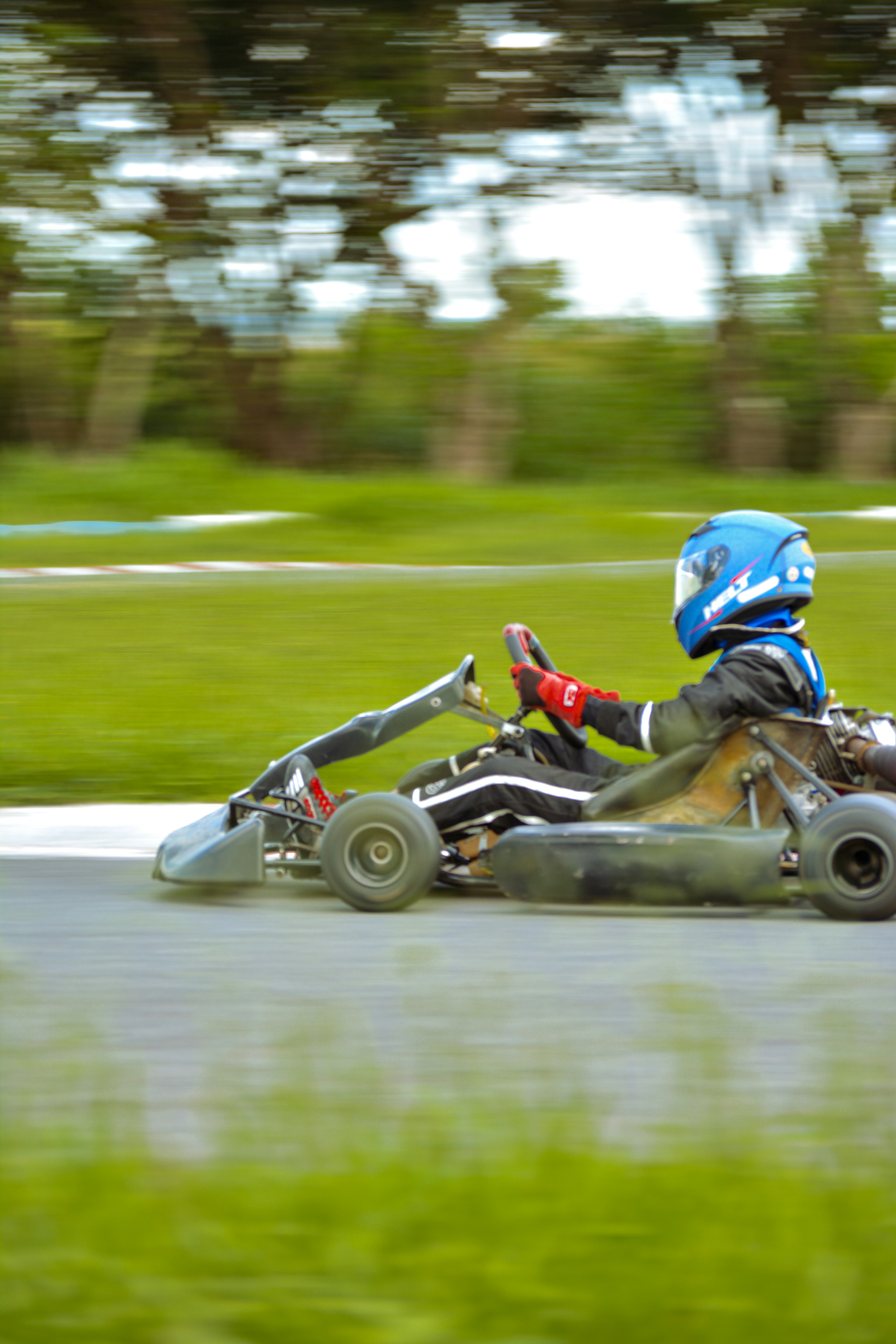 a person riding a go kart with a helmet on