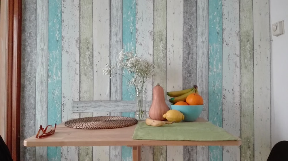 a wooden table topped with a bowl of fruit