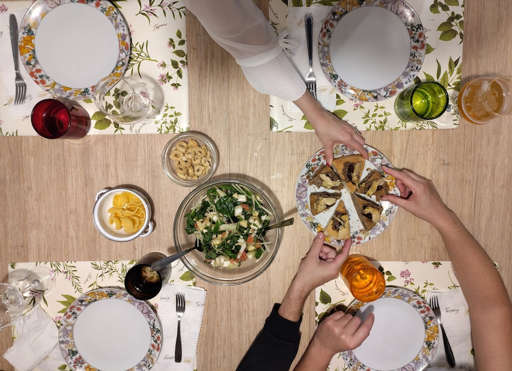 a group of people sitting at a table with plates of food