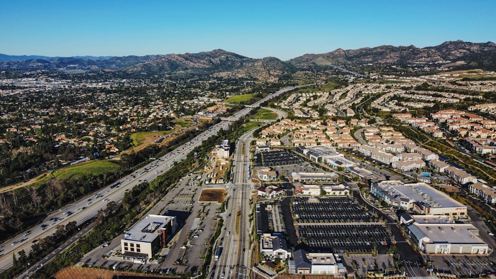 an aerial view of a city with mountains in the background