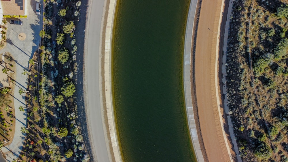 an aerial view of a road and a body of water