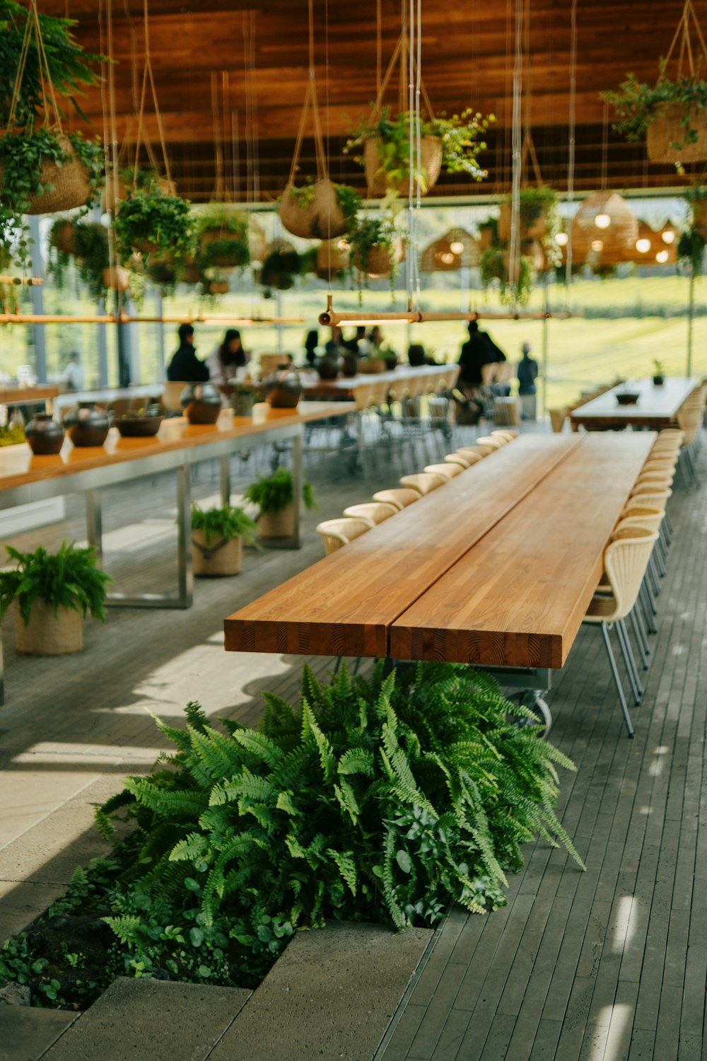 une longue table en bois assise à l’intérieur d’un bâtiment