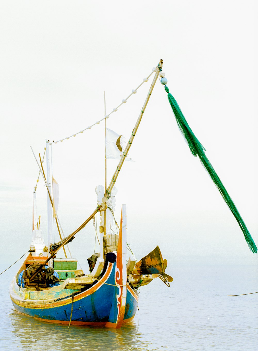 a blue and yellow boat floating on top of a body of water