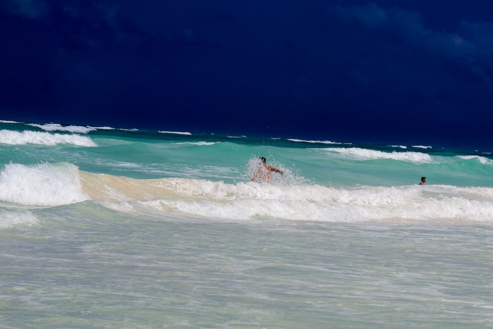 a man riding a wave on top of a surfboard