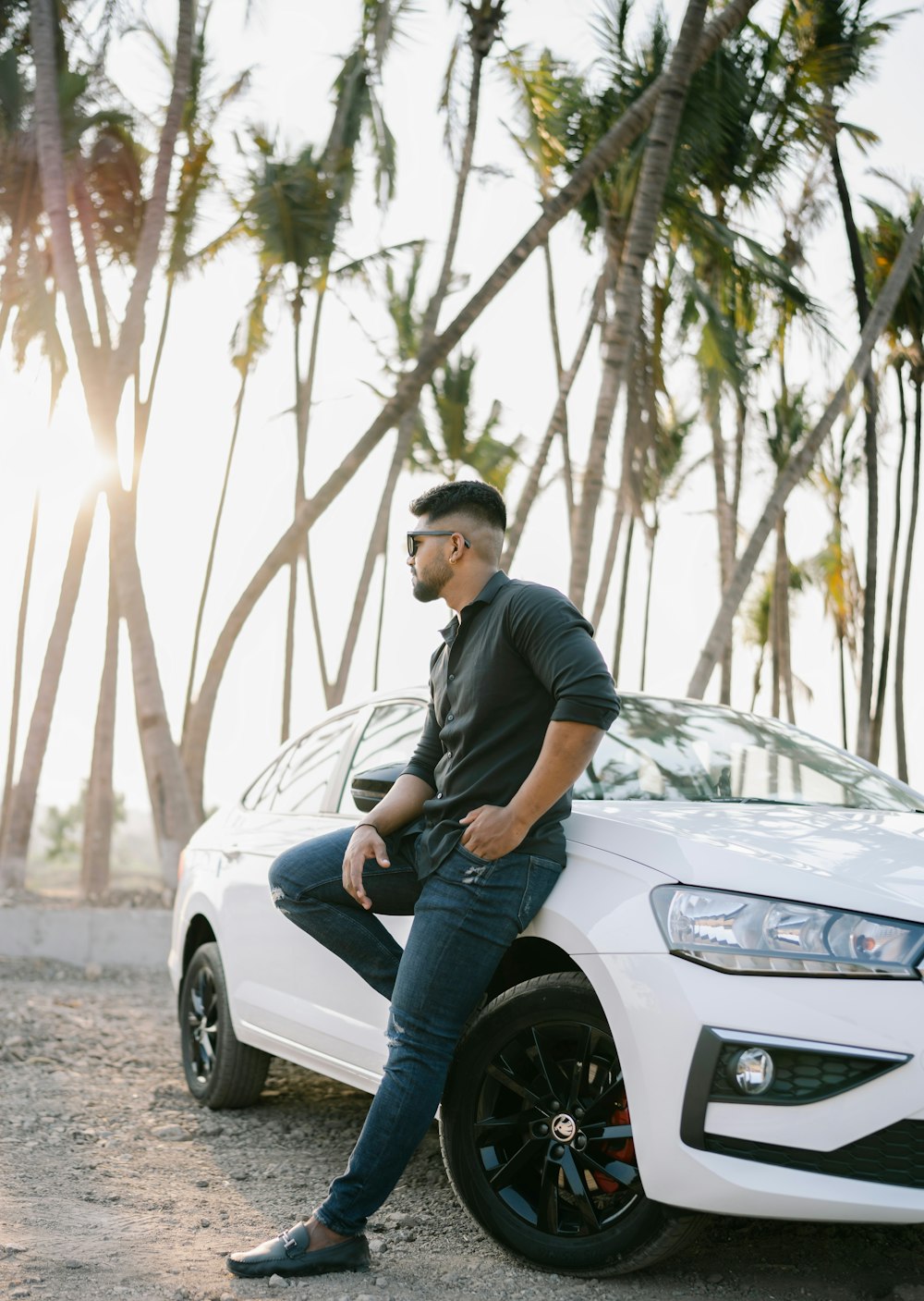 a man sitting on the hood of a white car