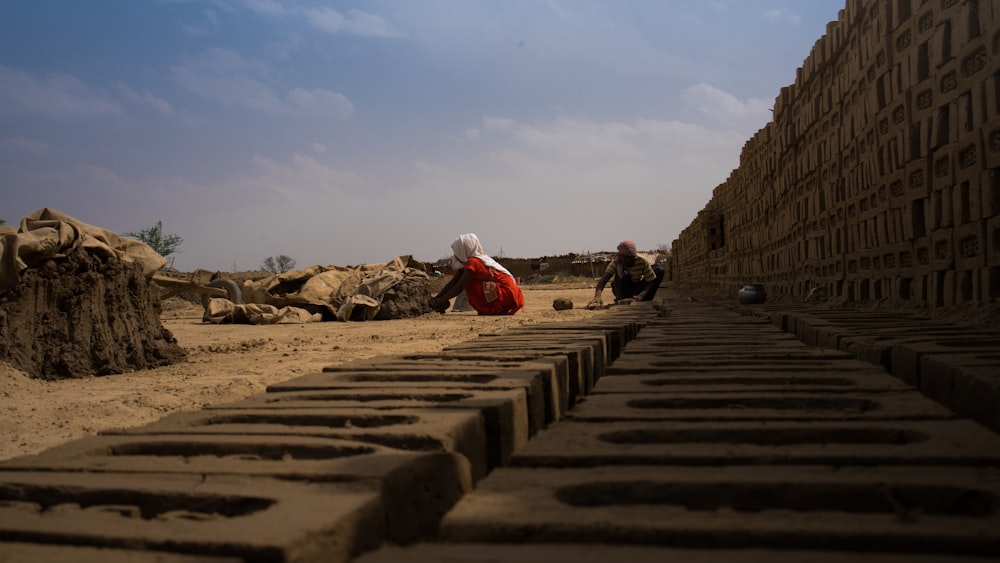 a group of people sitting on top of a sandy beach