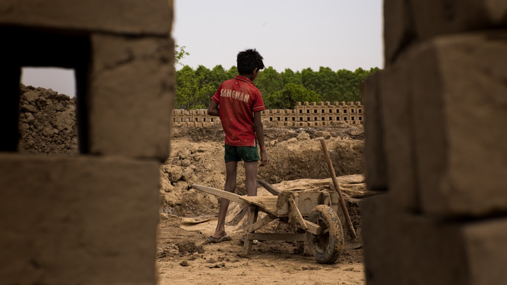 a man standing next to a pile of bricks